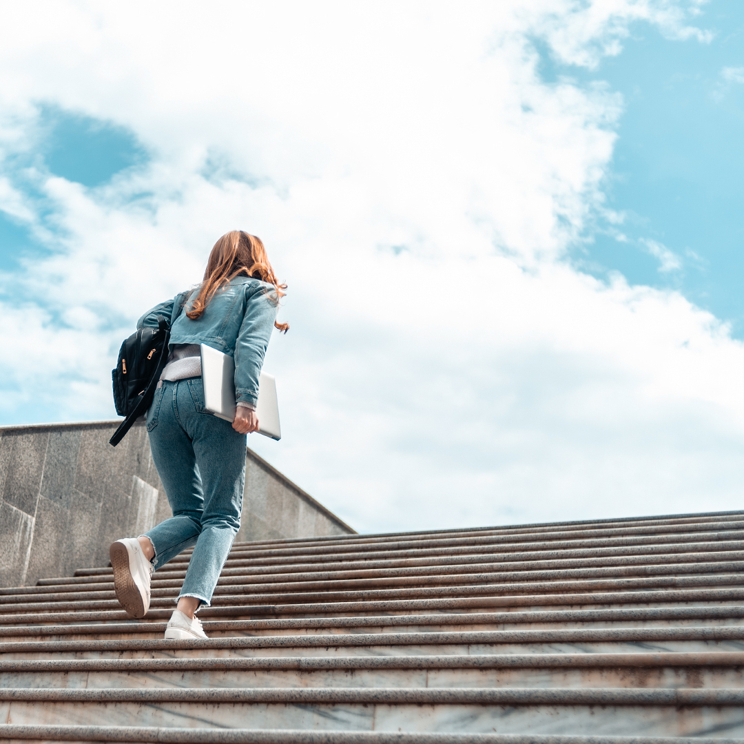 Studentin läuft eine steinerne Treppe nach oben