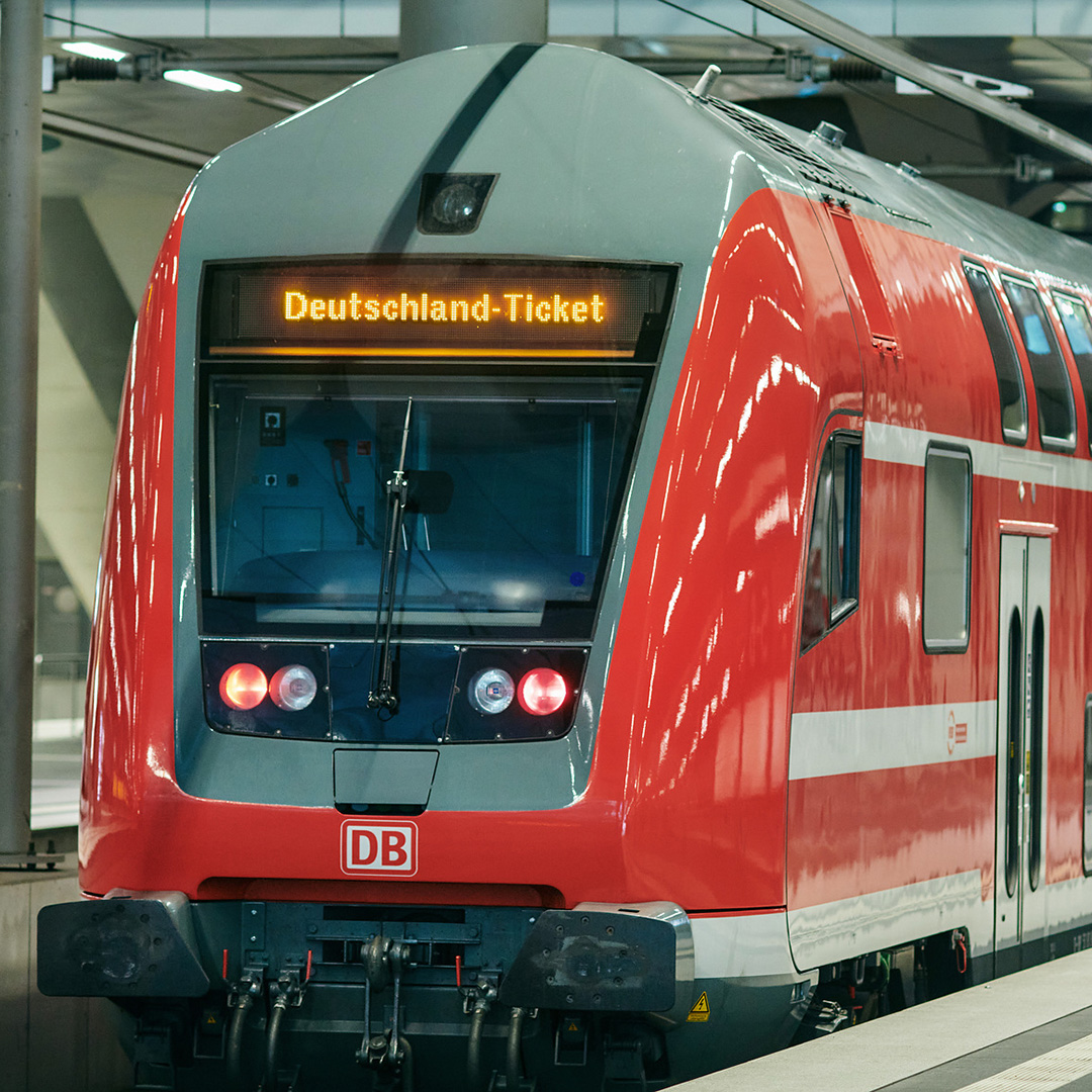 Roter doppelstöckiger Regionalzug der DB in Frontalansicht, auf der Anzeigetafel des Zuges steht Deutschland-Ticket