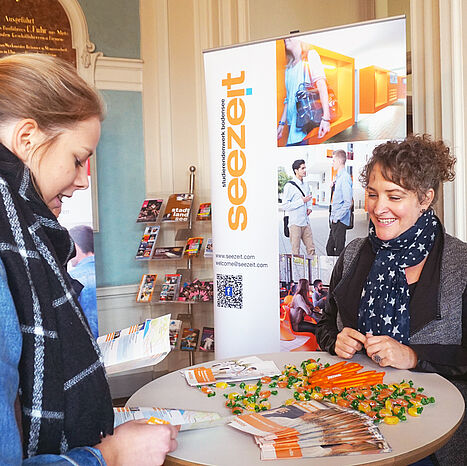 Mitarbeiterin berät Studierende am Seezeit Info-Stand
