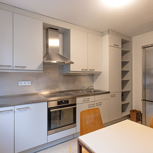 Kitchen in shared apartment with stove, oven, sink, refrigerator and seating area